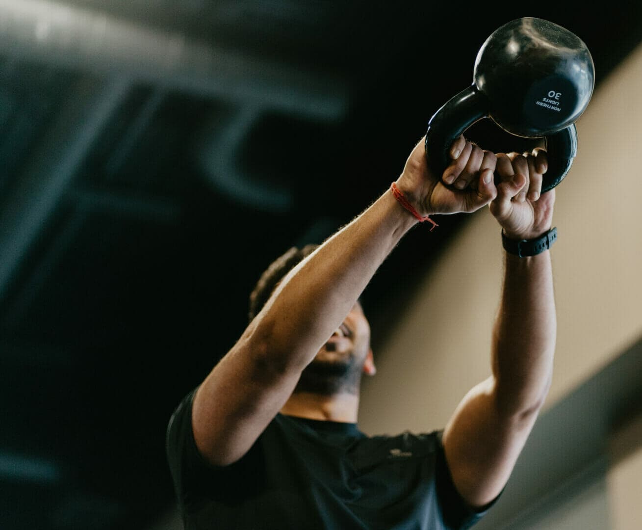 An athlete pressing a kettlebell overhead