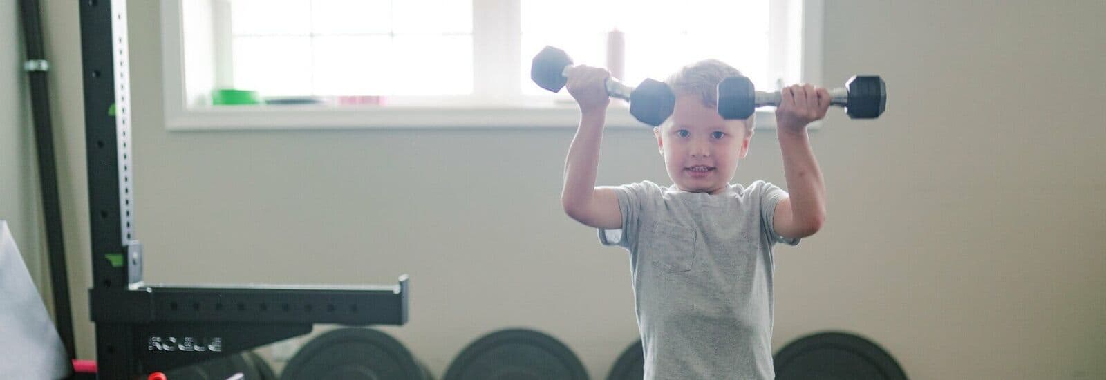 A young athlete pressing dumbbells overhead